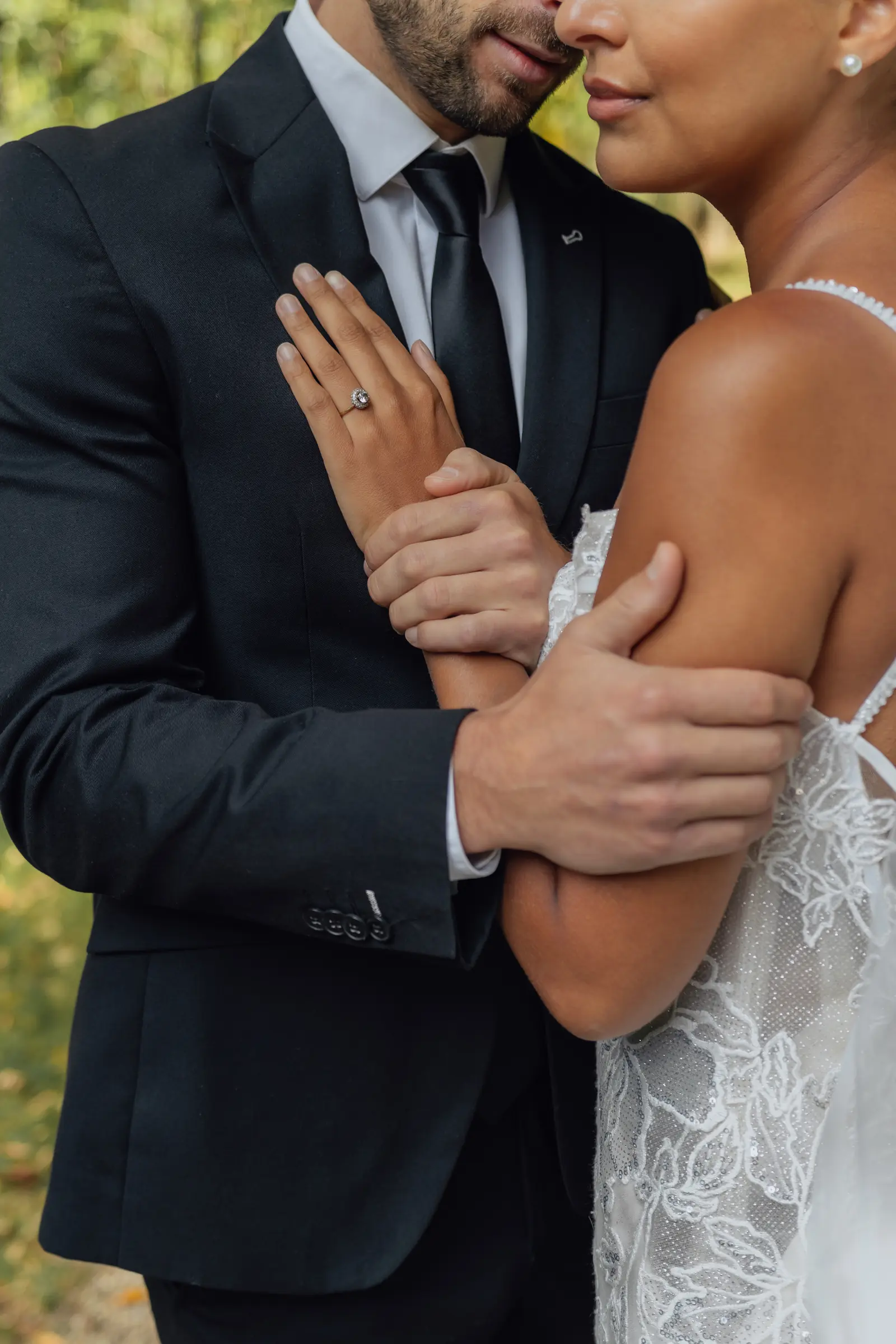 Handen met ring op het kostuum van de bruidegom